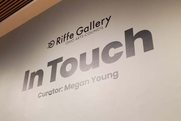 A sign on the wall states: "Riffe Gallery, In Touch, Curator: Megan Young"