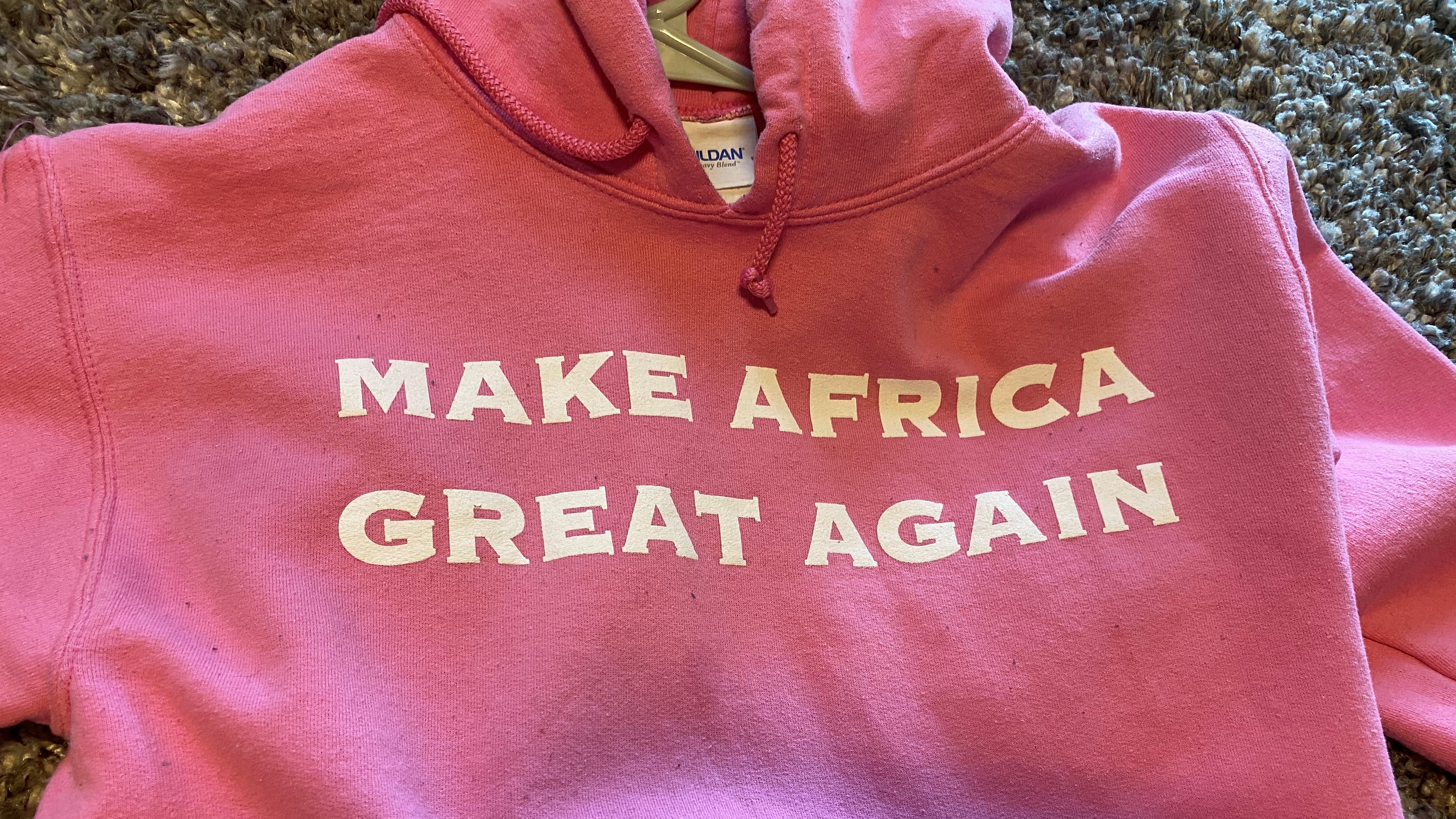 pink sweatshirt that states, "MAKE AFRICA GREAT AGAIN"