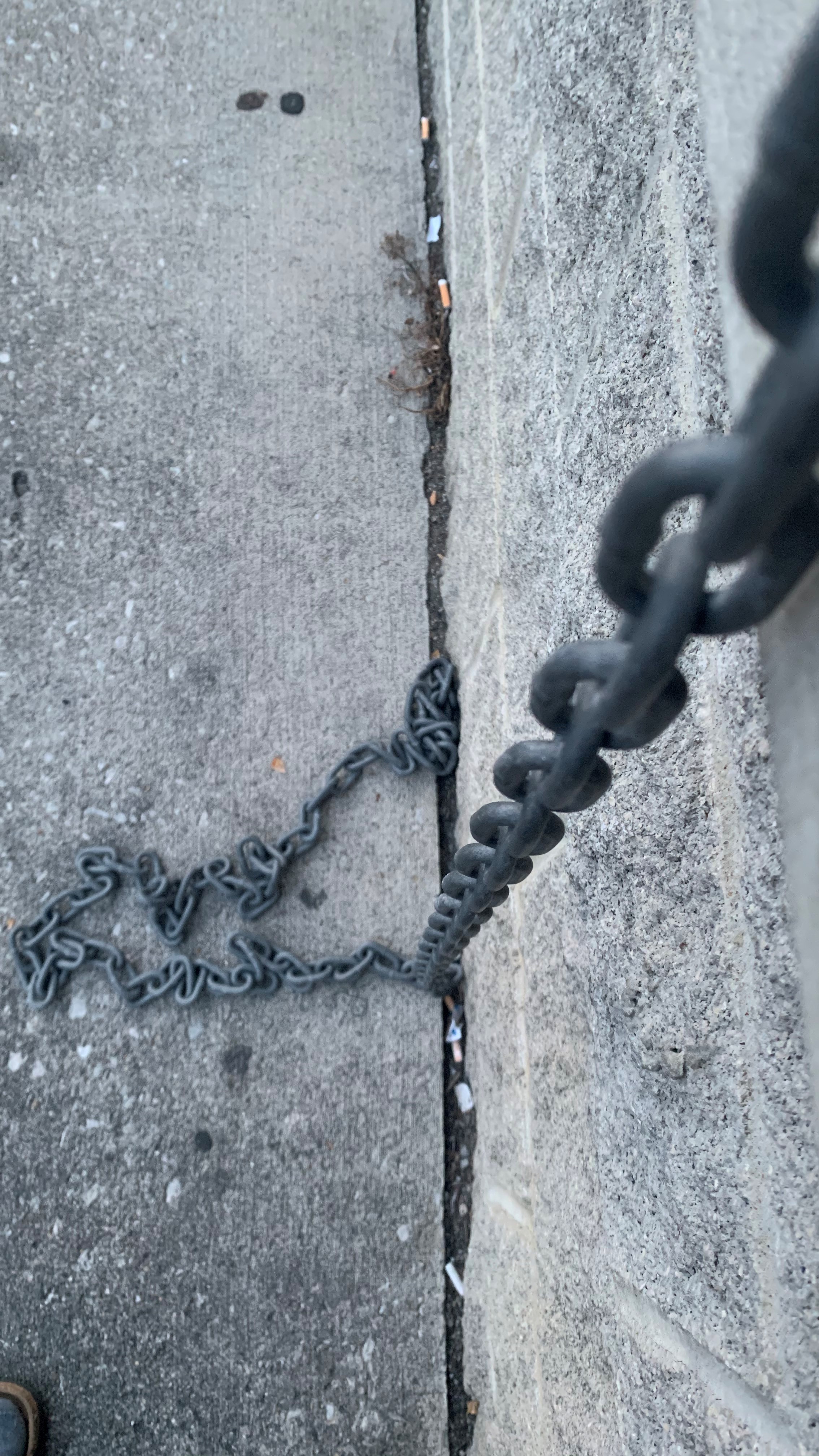 iron chain hanging from concrete wall