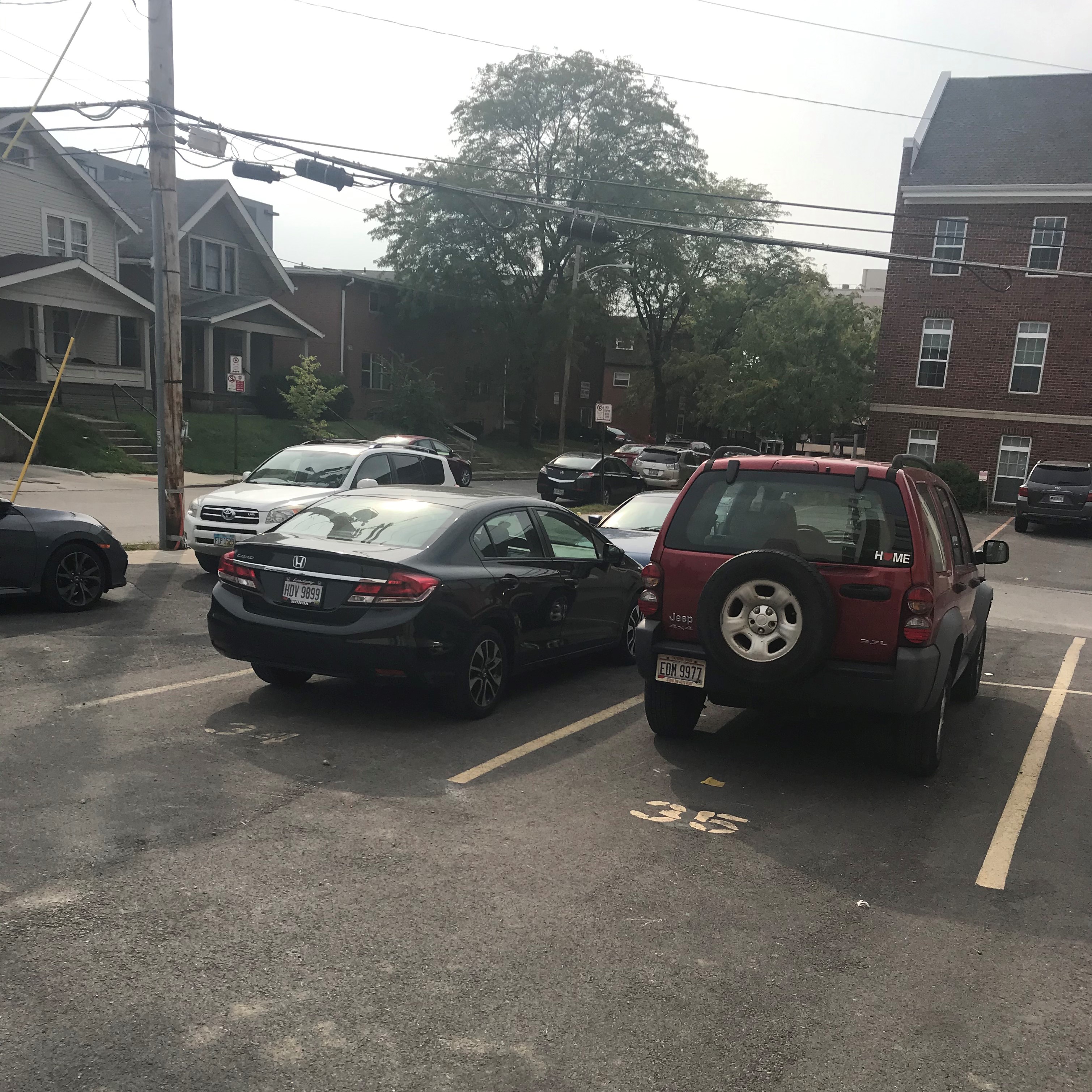 two cars parked in numbered parking spots outside