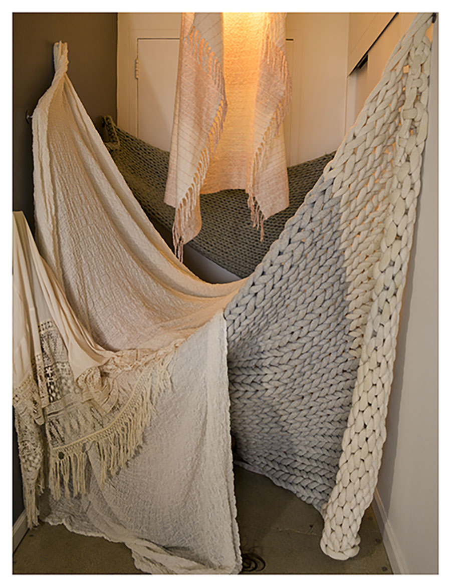 crocheted blankets hanging from wall