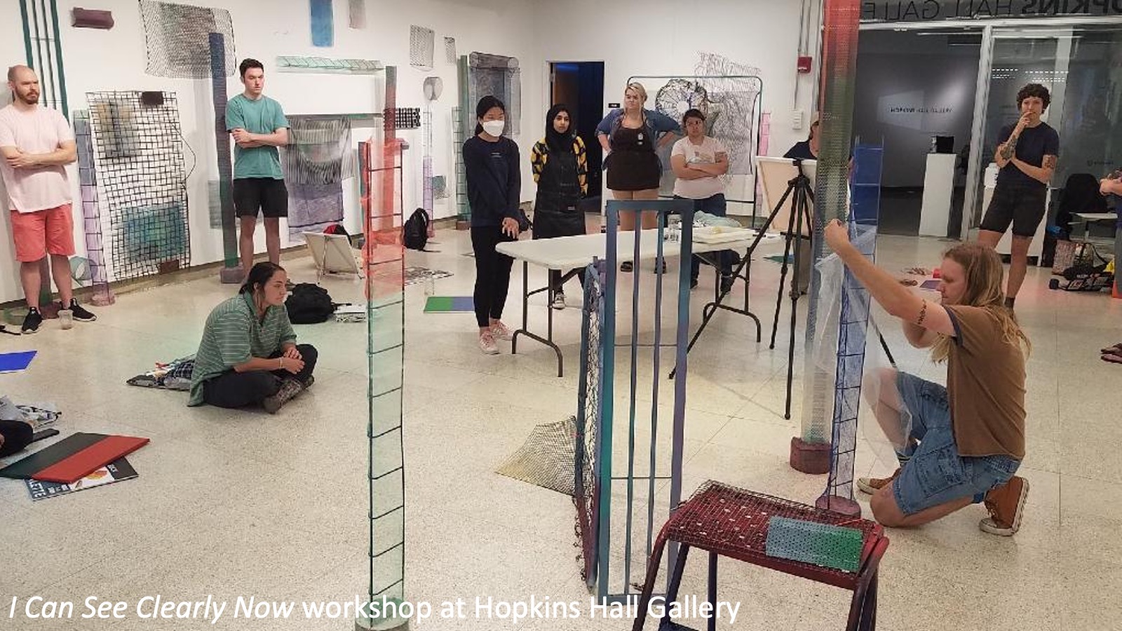 Visitors observe an artist during a workshop for the exhibition "I Can See Clearly Now."
