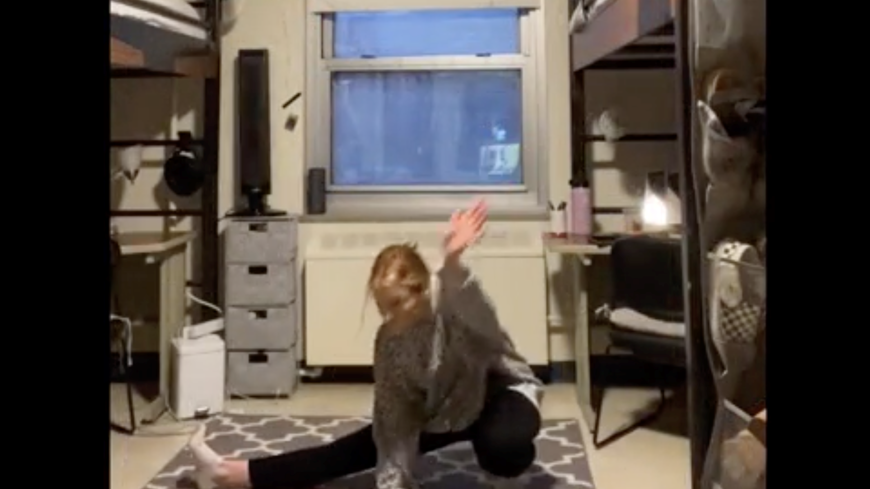 A dancer on the floor of a dorm room.