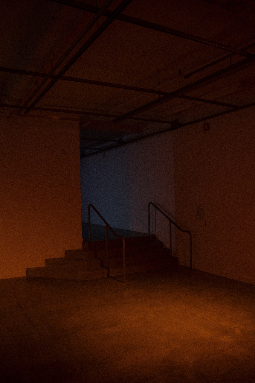 An empty gallery is dimly lit with an orange glow
