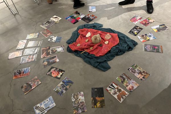 The finished collages are laid out on the floor in a circular formation during the final debrief. 