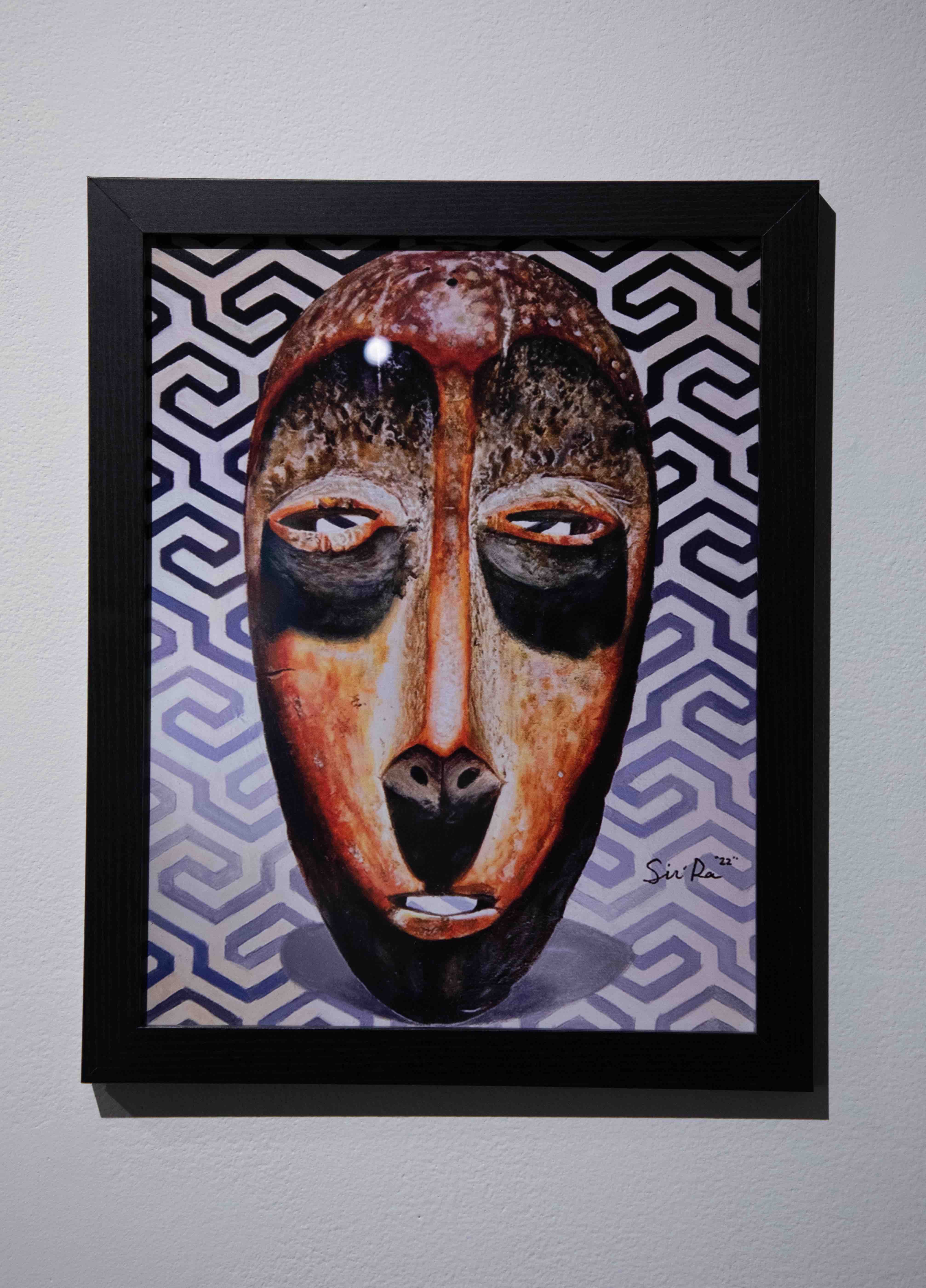 Print of a wood face sculpture surrounded by colorful geometric lines