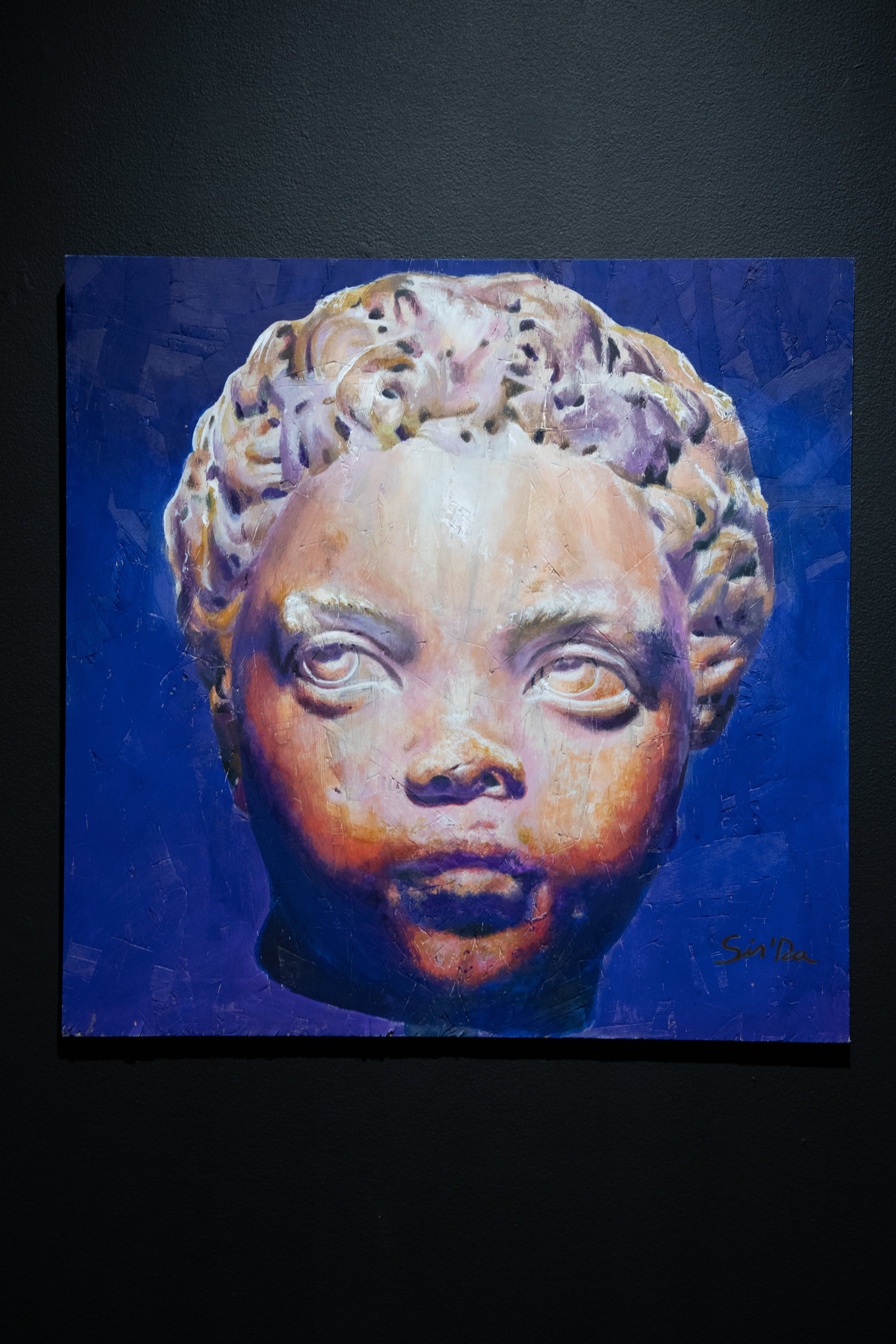 Painting of a baby's head that resembles a greek sculpture. Their facial expression is stoic and reserved. 