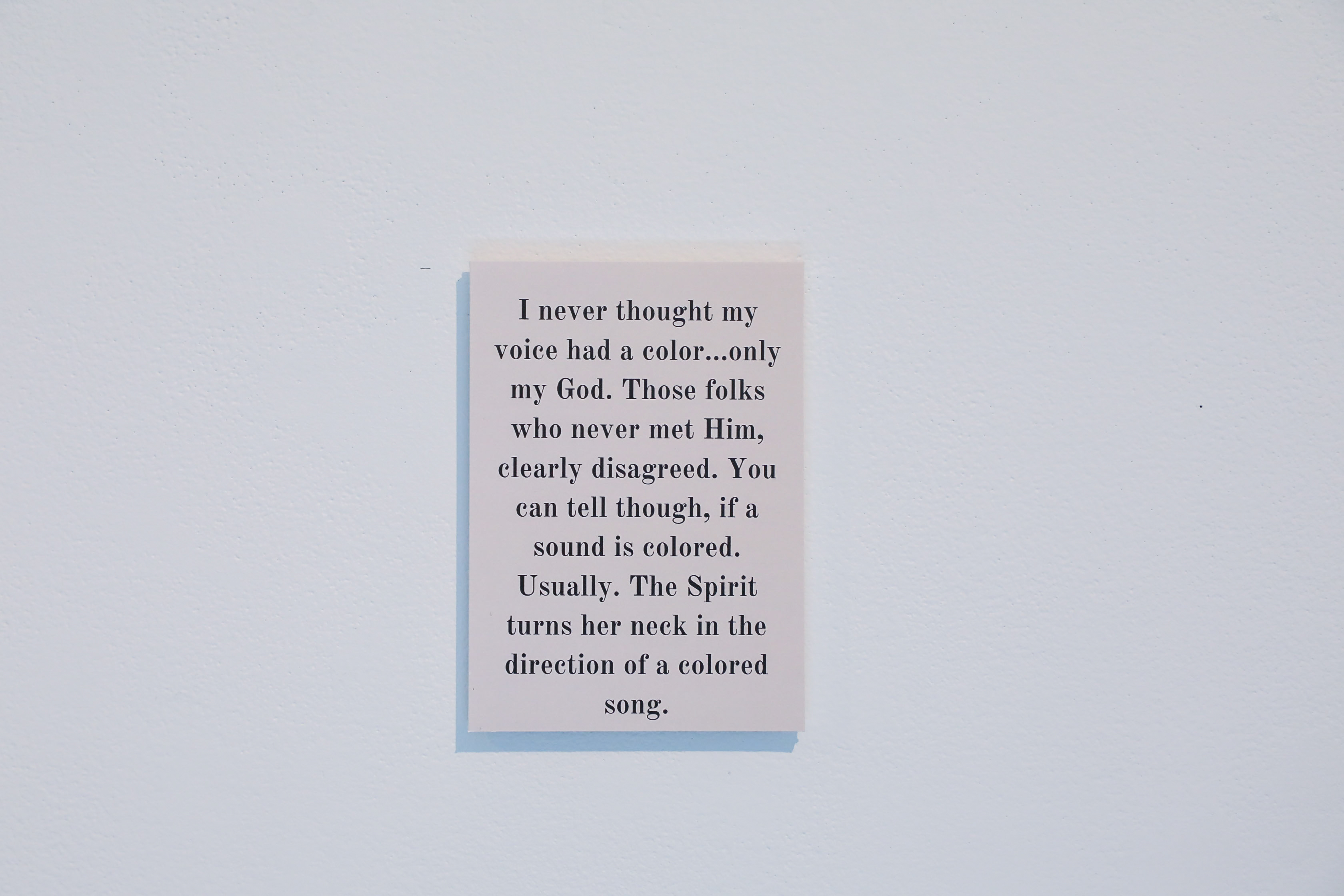 A poem on a light grey background. The poem says, “I never thought my voice had a color…only my God. Those folks who never met Him, clearly disagreed. You can tell though, if a sound is colored. Usually. The Spirit turns her neck in the direction of a colored song.”