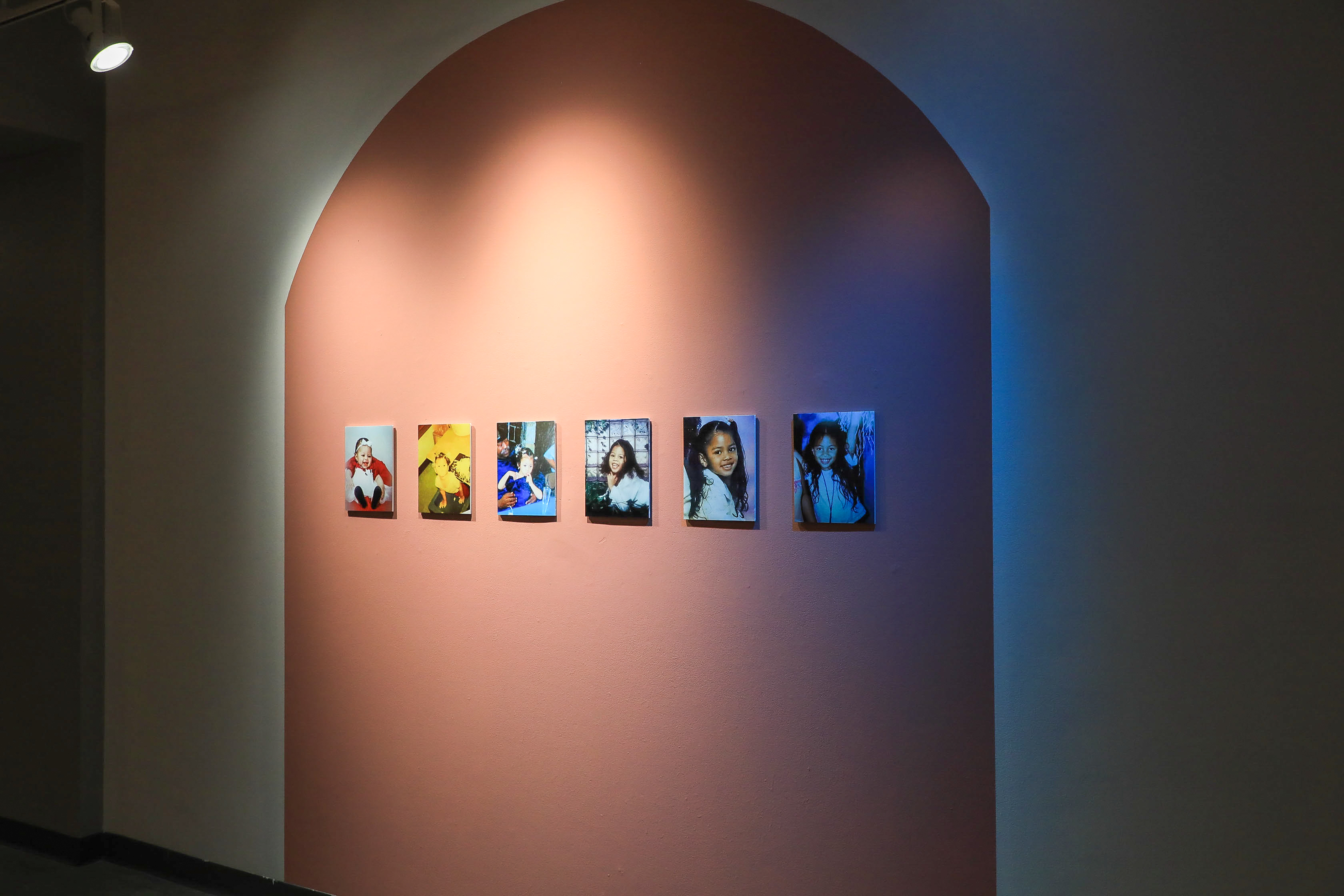 Six different family photos on top of a red-orange painted shape. 