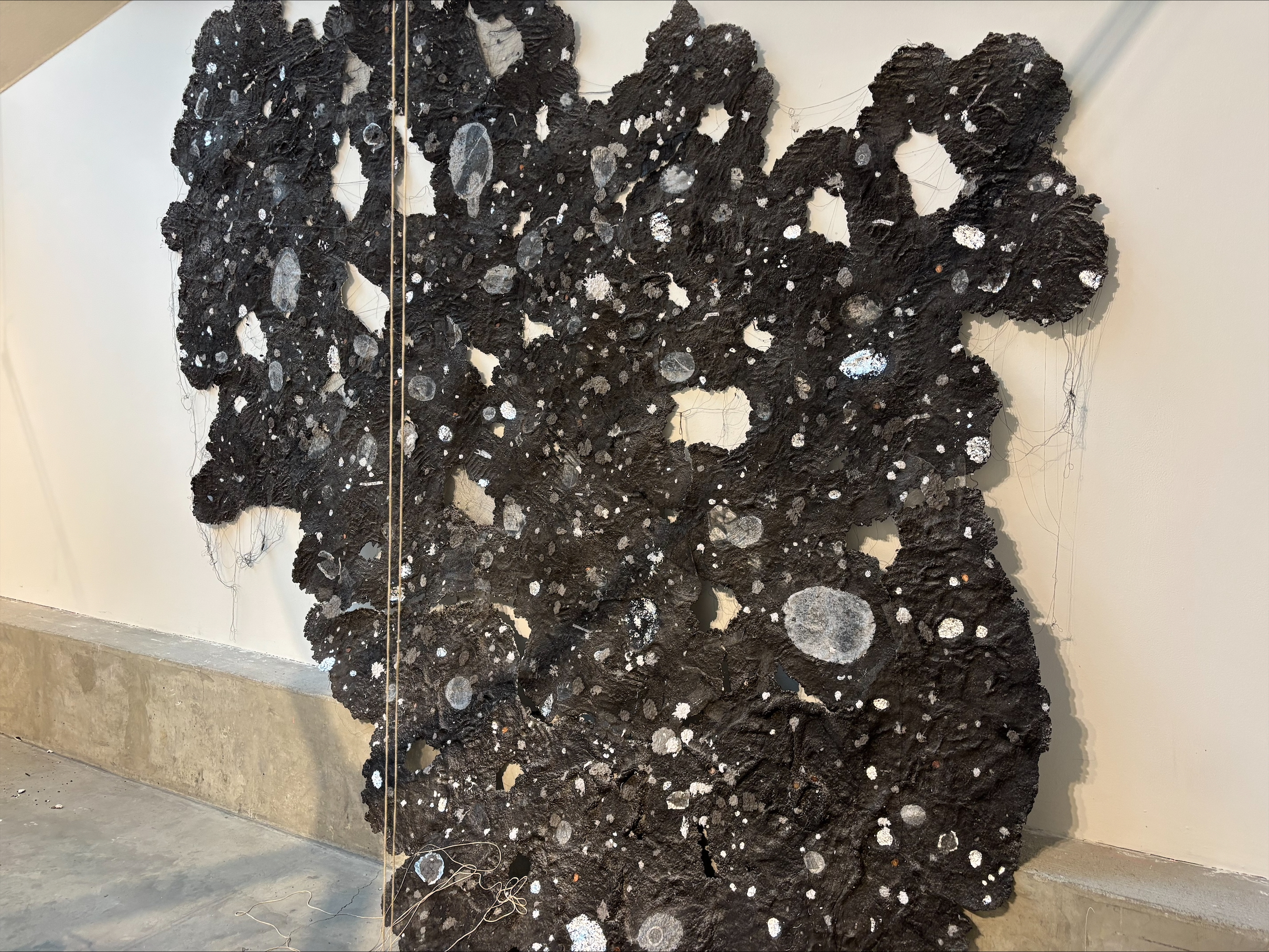 black sculpture in irregular shapes on a gallery wall