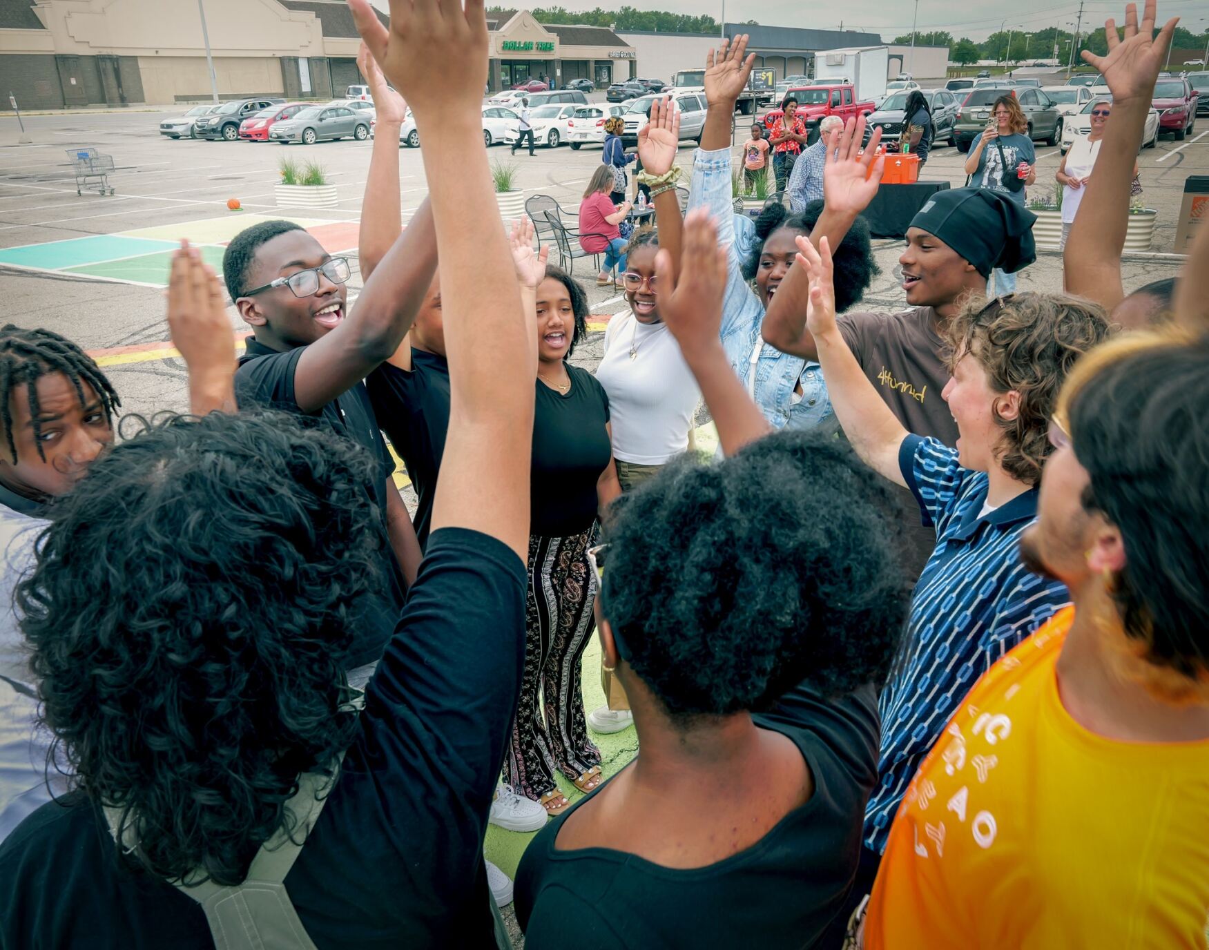 a group of 10 students high-fiving and smiling