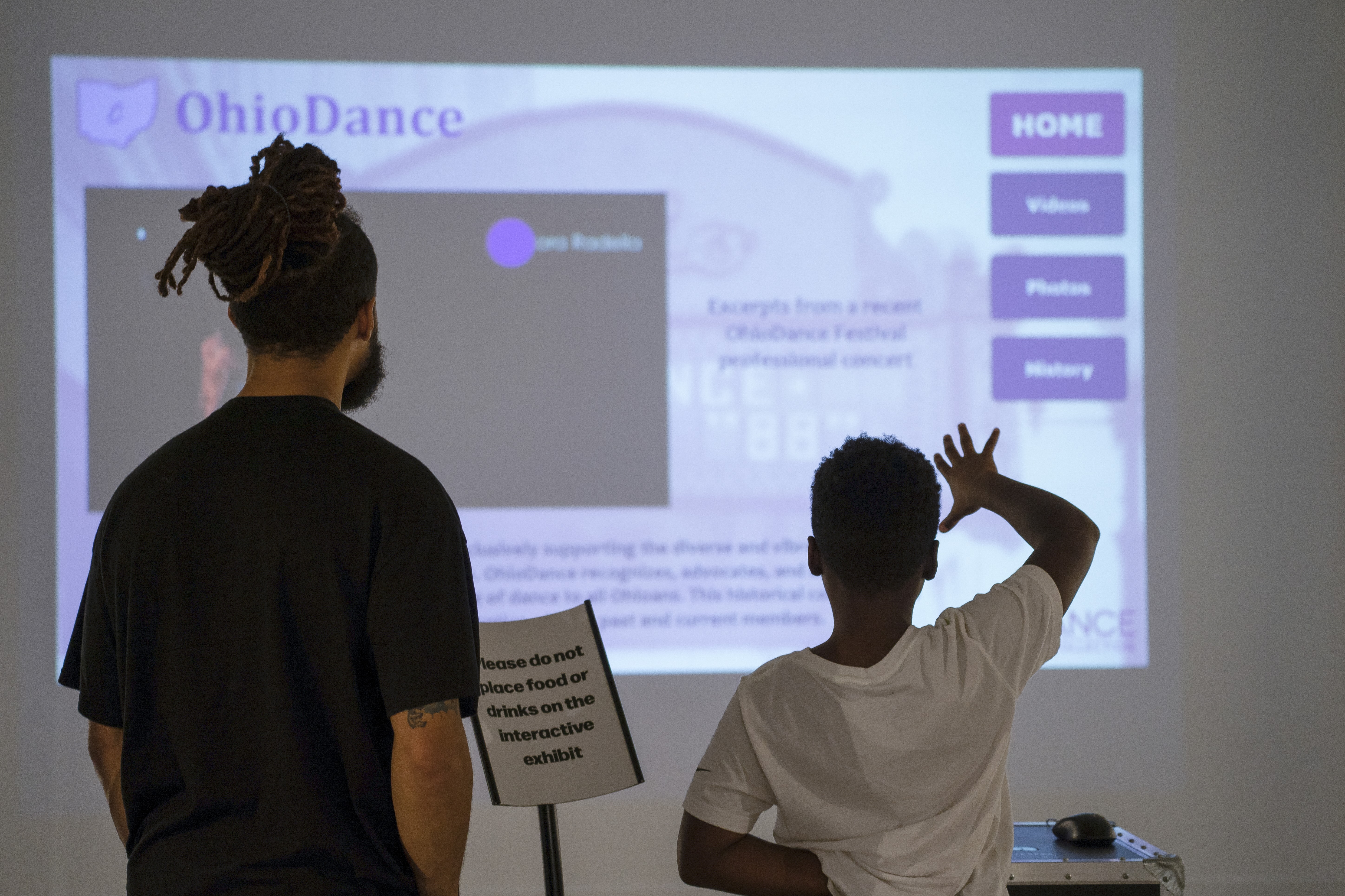 father and son using the touchless dance history interface