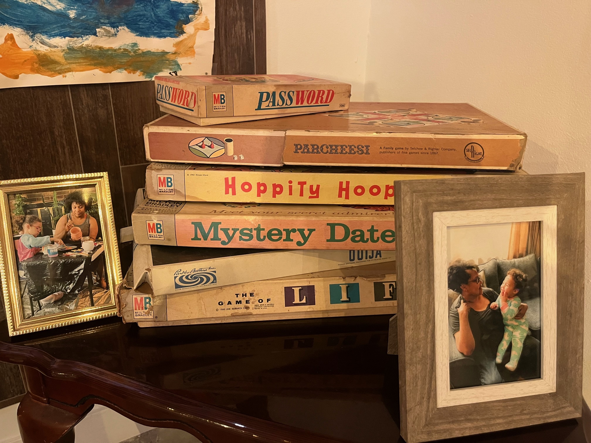 A stack of vintage board games with family photos on each side of the stack.
