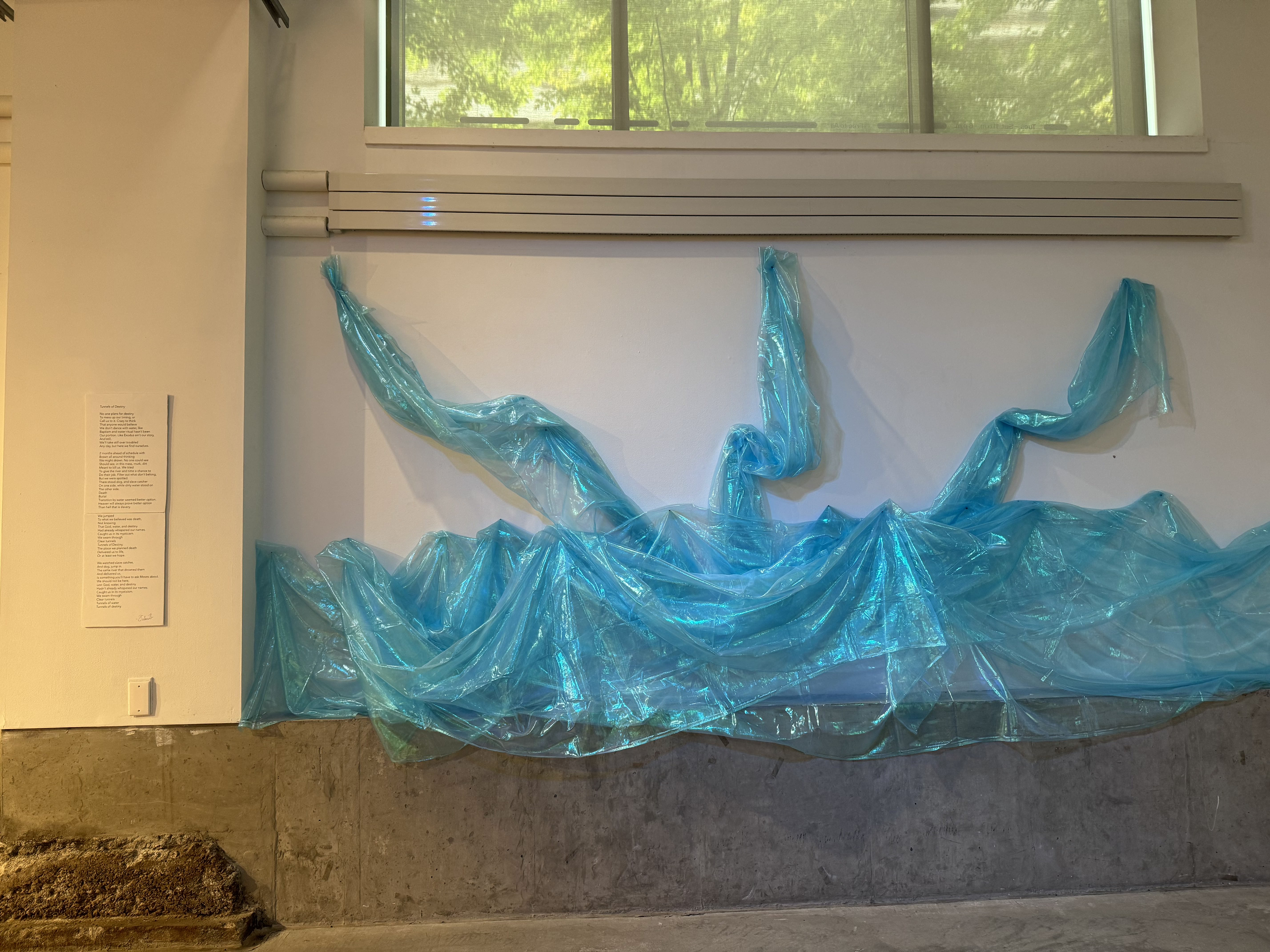 blue fabric on the wall next to a poem