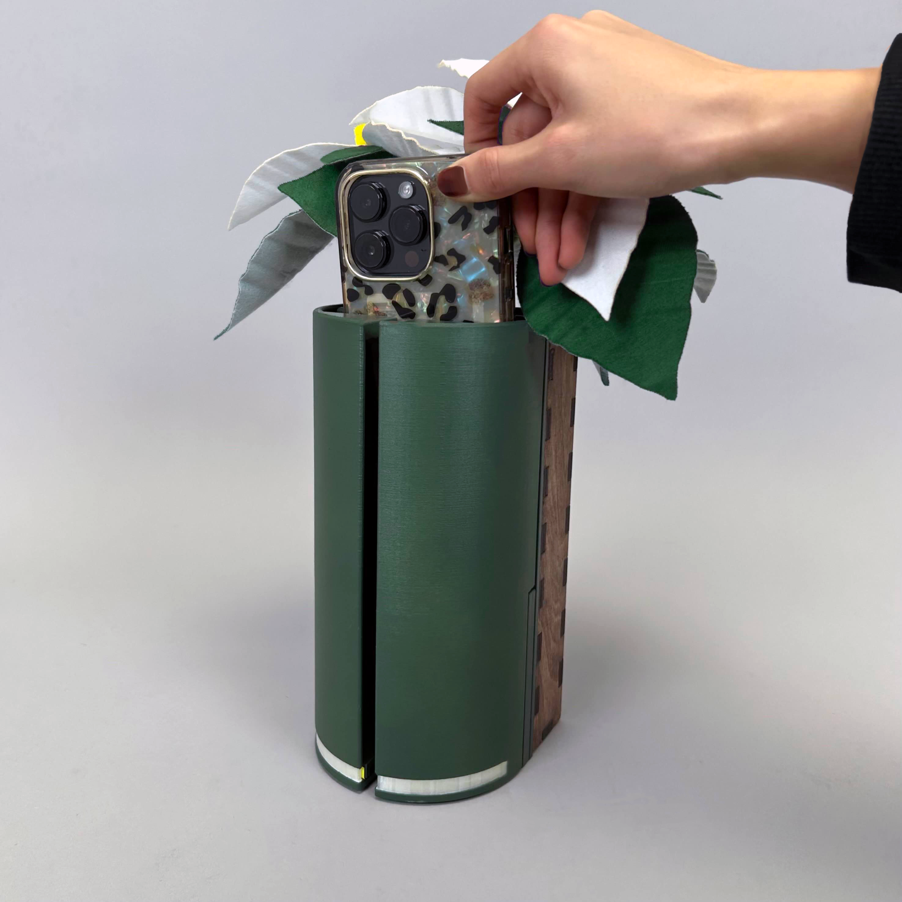 tall green container with felt flower used for holding a phone