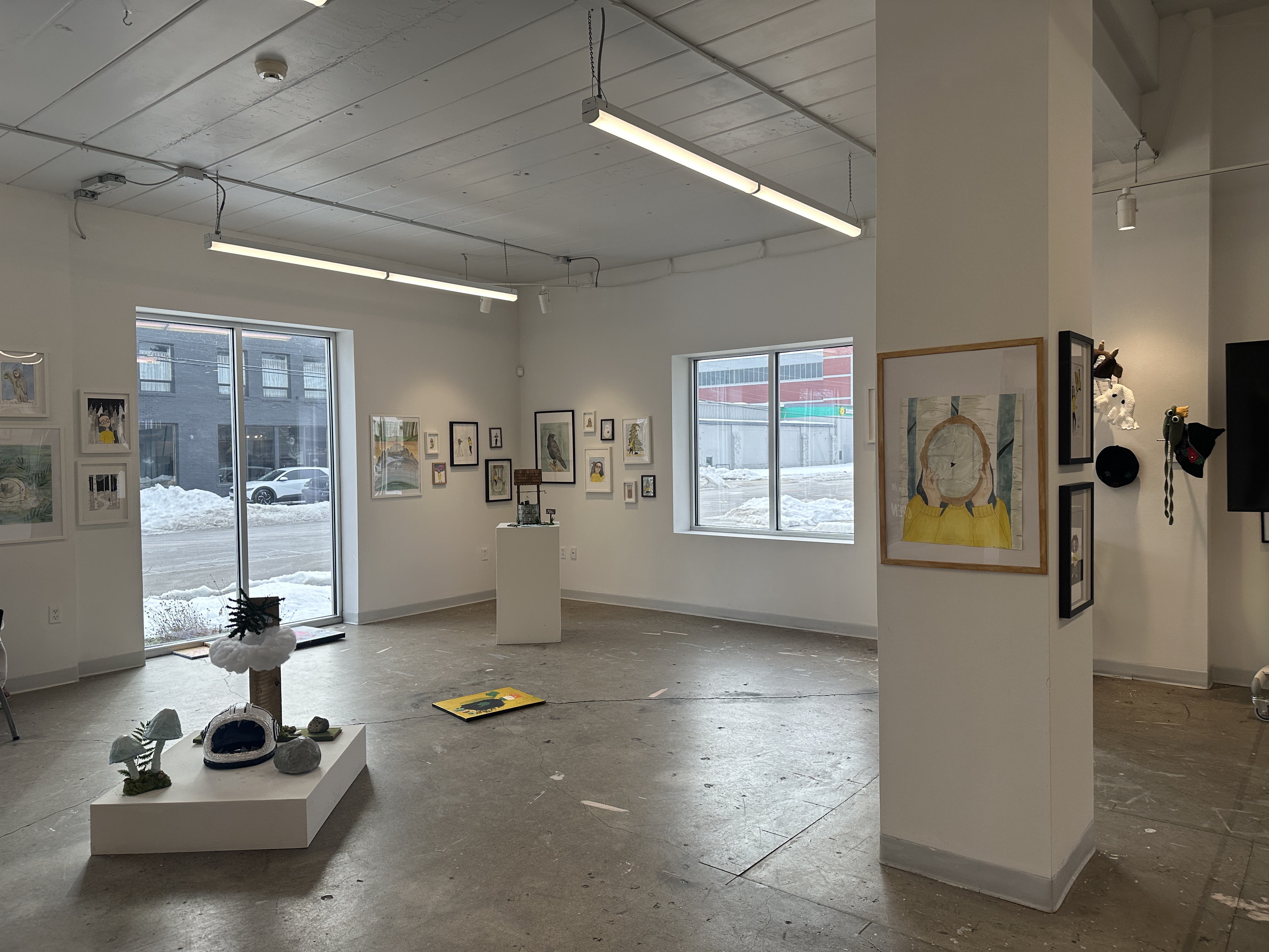 well-lit gallery space with sculptures and paintings