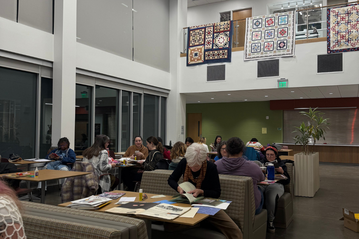 people collaging in a room that has quilts on the walls