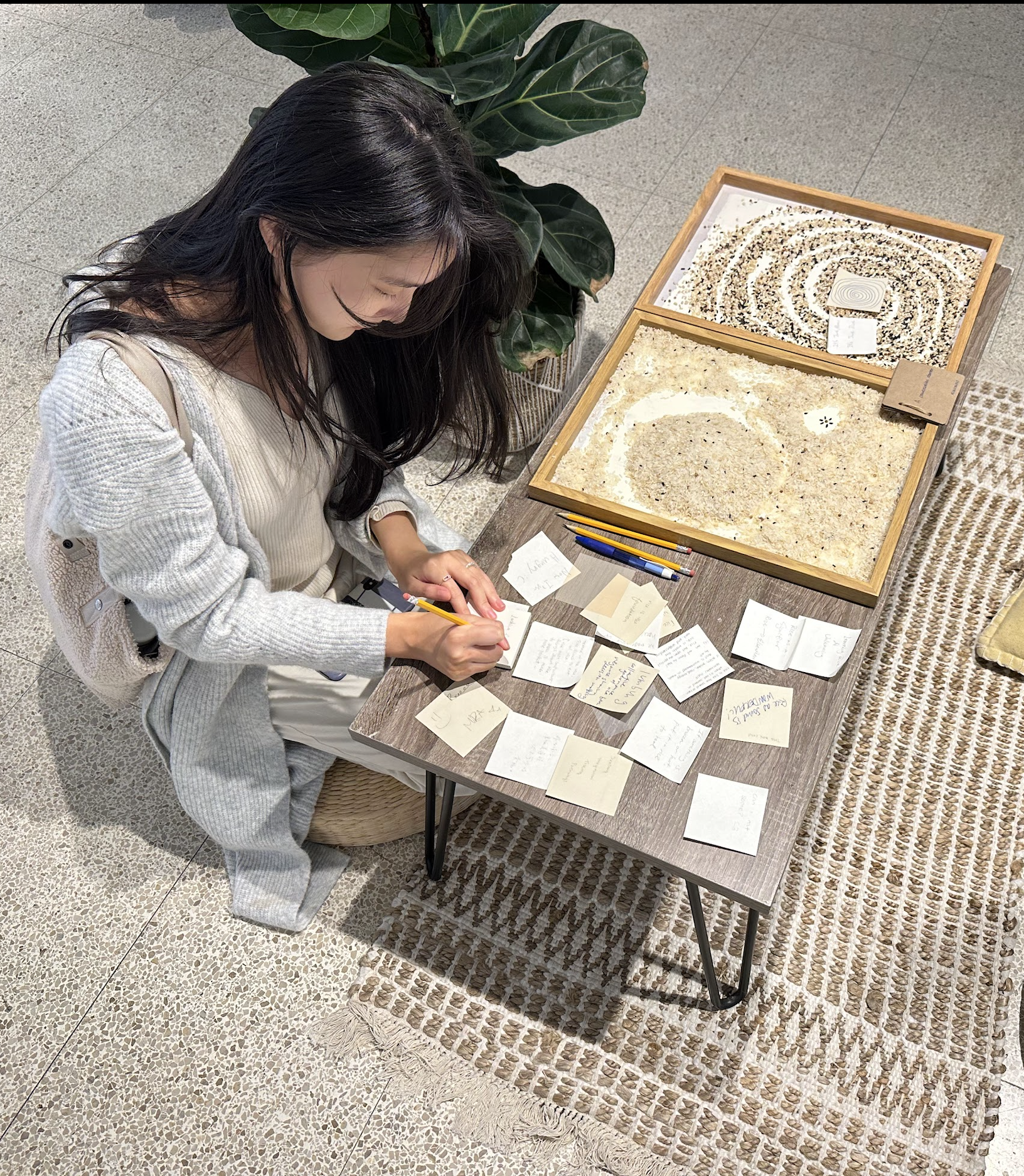 Xiaoxiao responding to visitors' notes at a low table