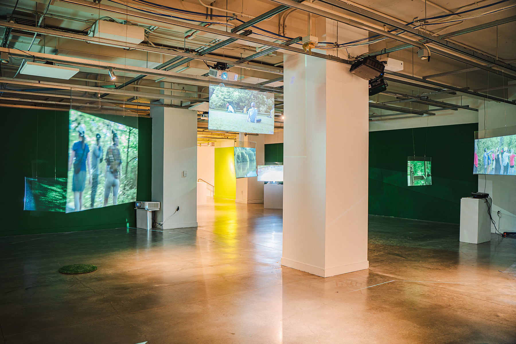 the gallery filled with hanging screens showing the park performances