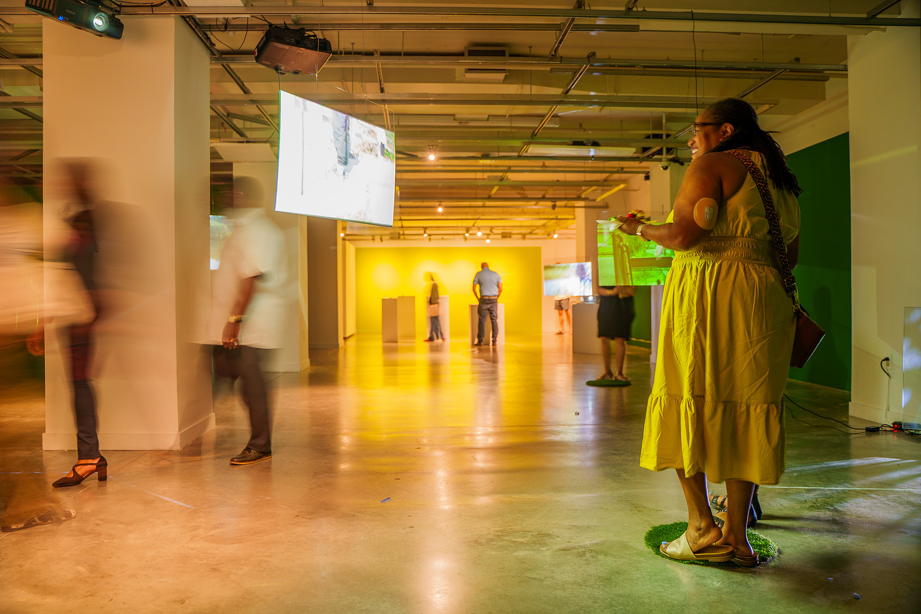 visitors looking at the video screens in the gallery exhibition