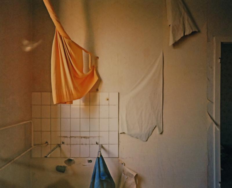 Interior of an abandoned building with cloths hanging from various places