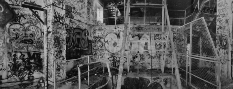 Interior of an abandoned factory with walls covered in graffiti 