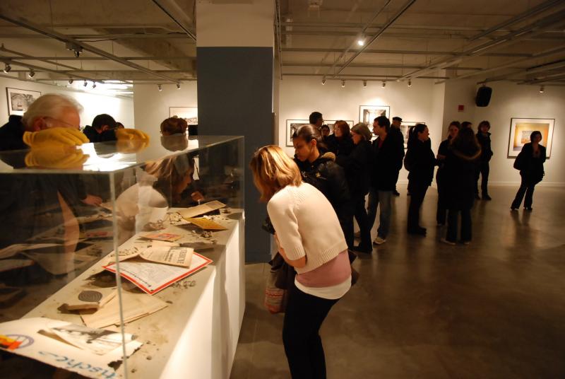 Reception attendees examining artifacts from Dresden displayed alongside Marsh’s photographs.