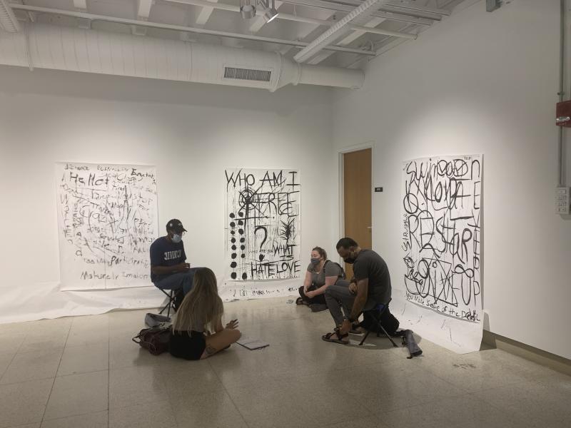 Students at Hopkins Hall Gallery surrounded by drawings from Improvisational Ink workshop
