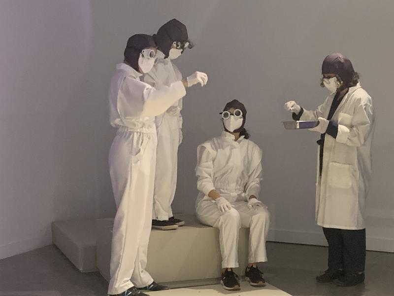 Artists in white suits performing Seed Lab