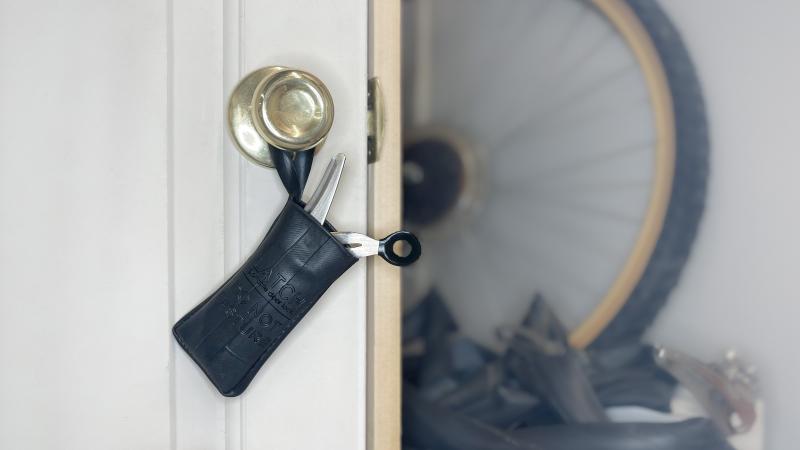 The Latch storage pouch hangs on a doorknob with the door lock inside.