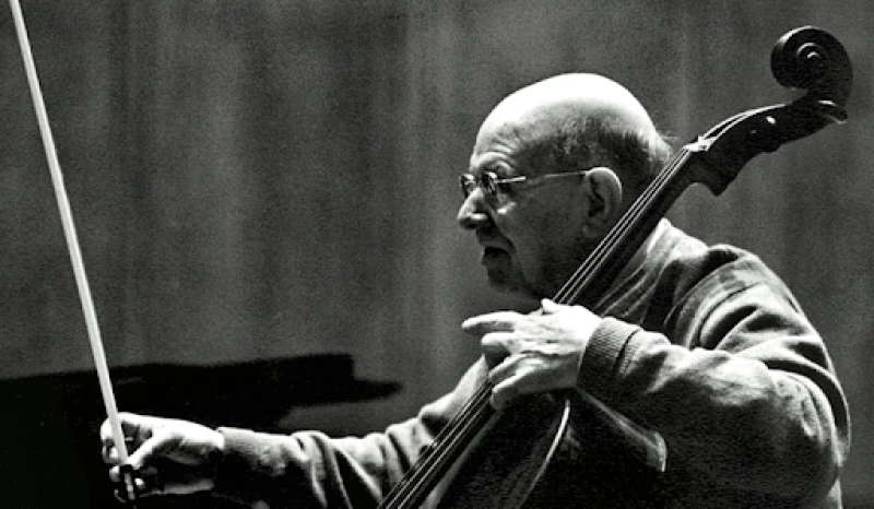 A black-and-white photograph of an old man playing the cello