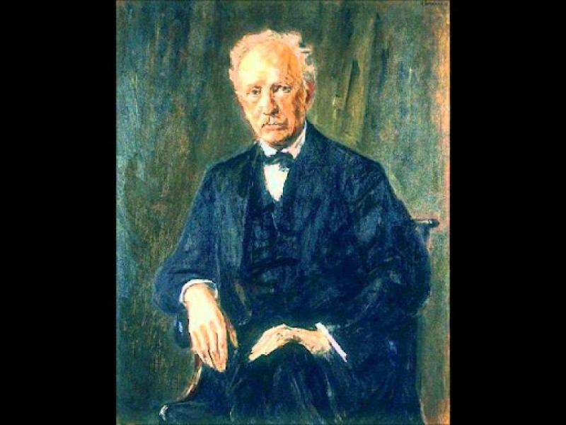 A painting of Richard Strauss, looking into the camera and wearing a blue suit in front of a green background
