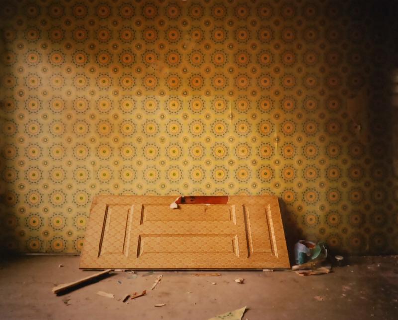 a door laying on its side inside an abandoned apartment