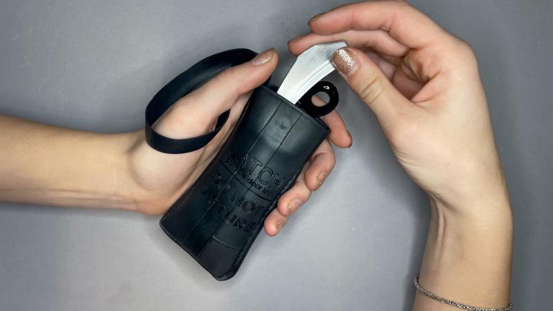 A model pulls the Latch door lock out of its storage pouch.