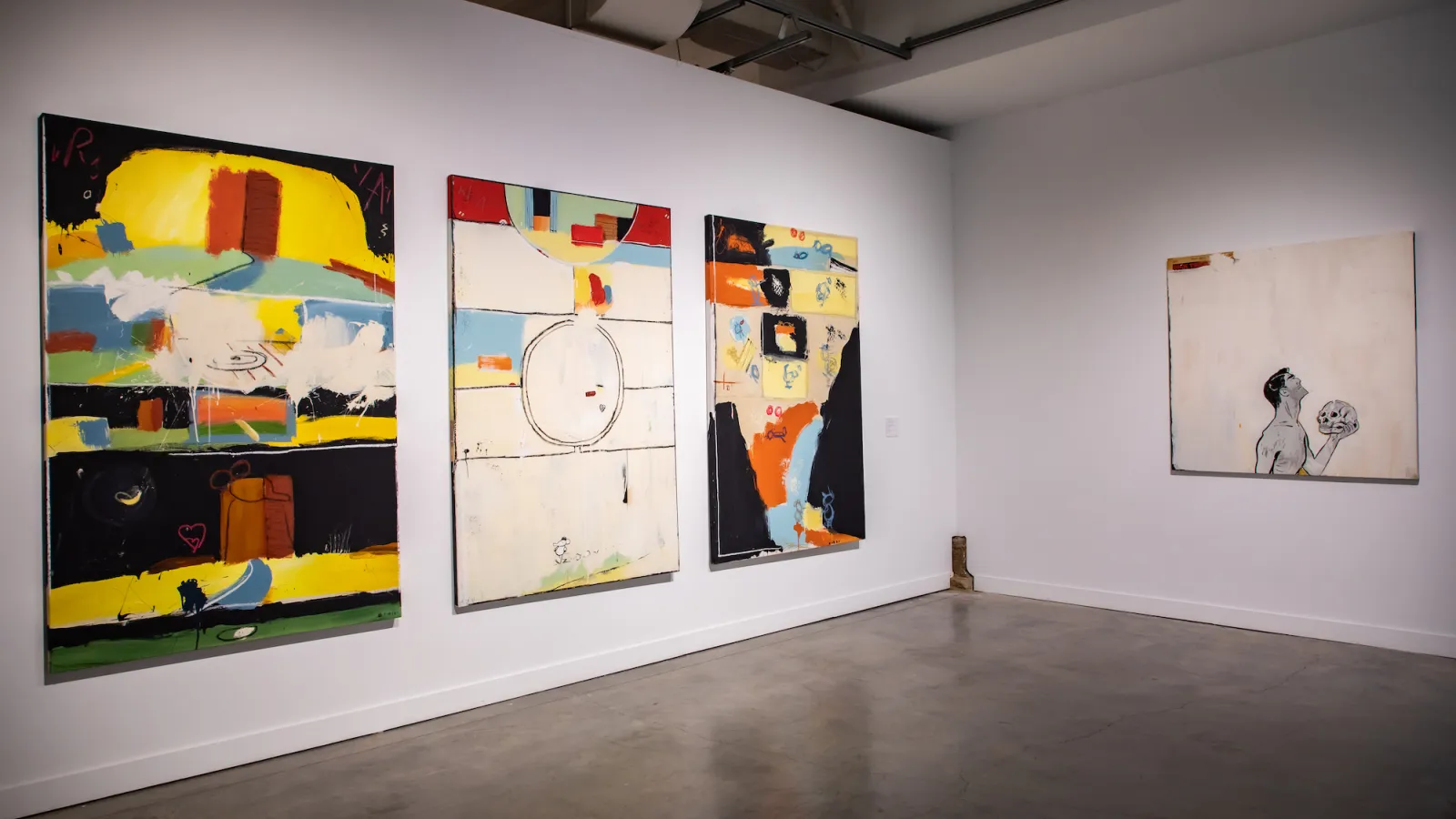 4 large canvases one has a man holding a skull 