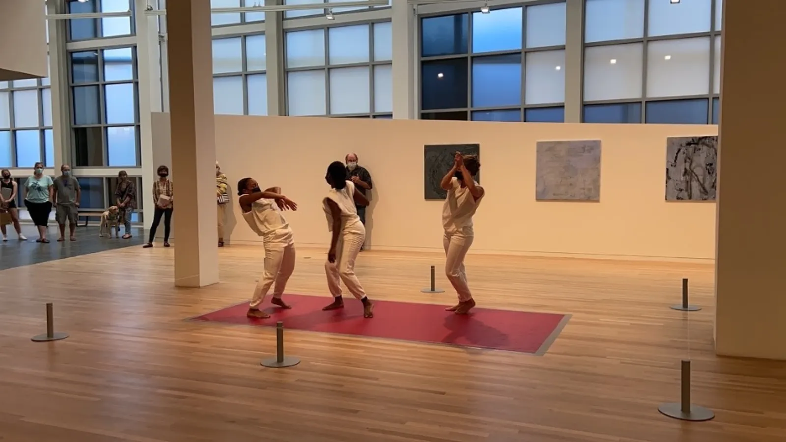 people dancing on a red mat with people the background watching