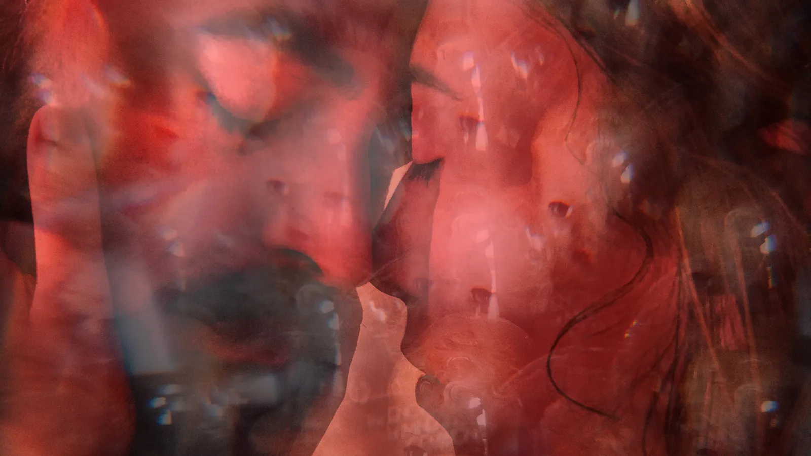 two faces close to each other distorted in a red filter