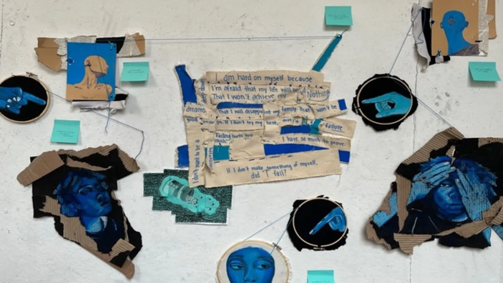 Collage of painted faces and words on cardboard