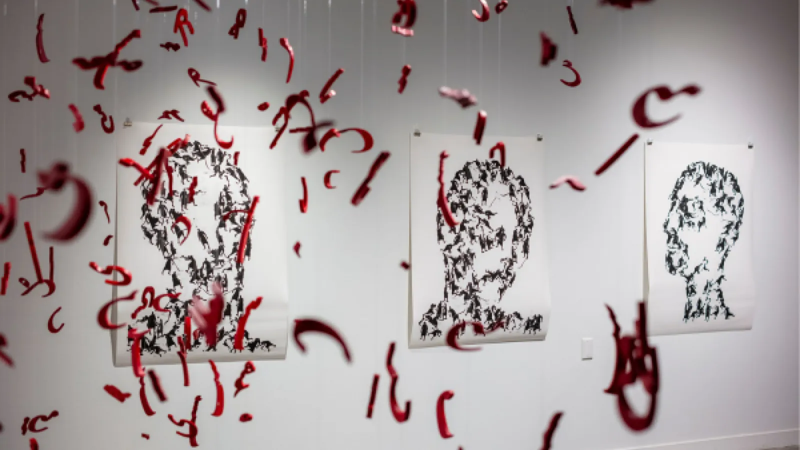 Photo of hanging artwork and portraits on the wall