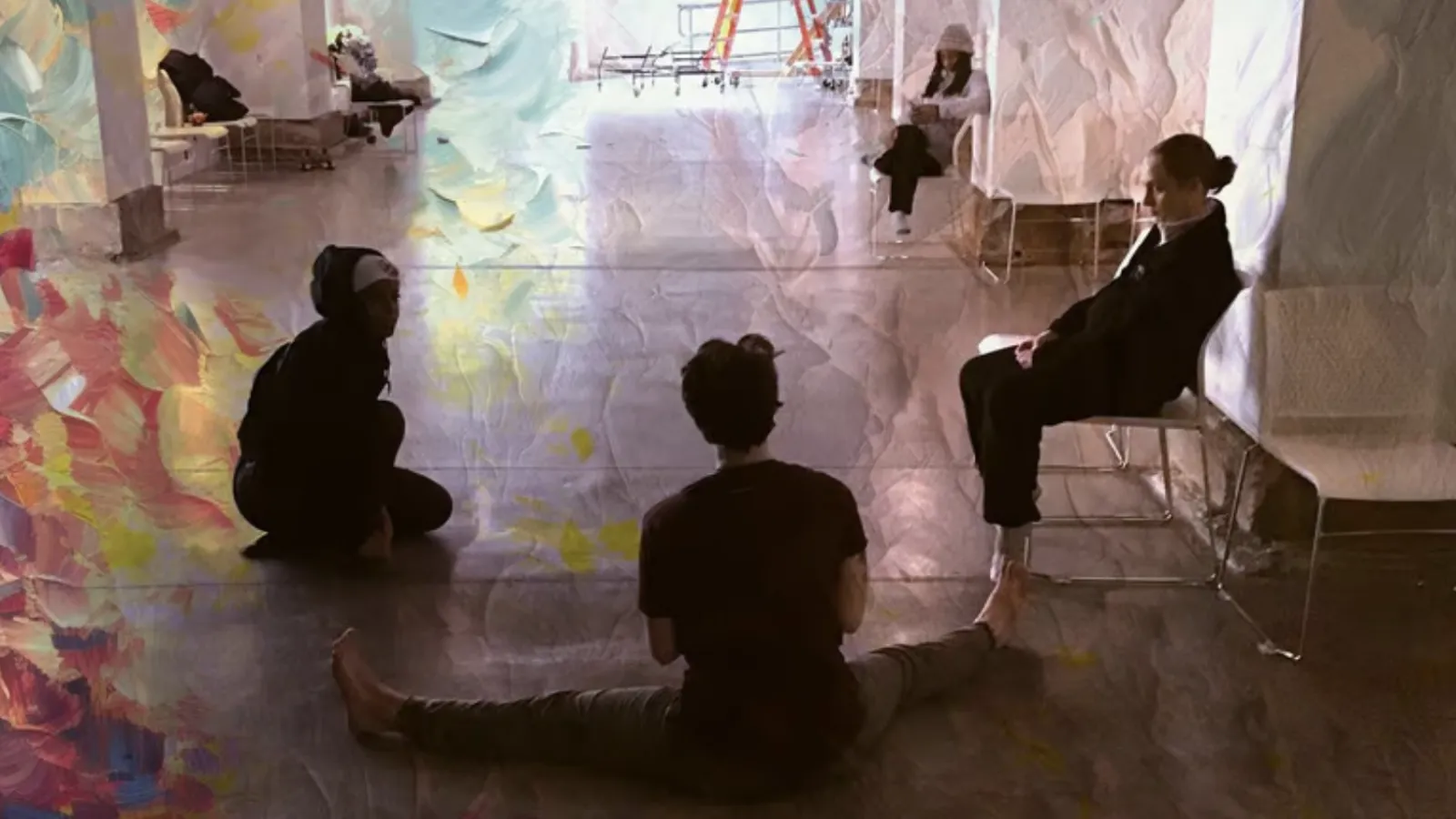 Nico and other artists of Grieving Landscapes sitting on the floor of Urban Arts Space