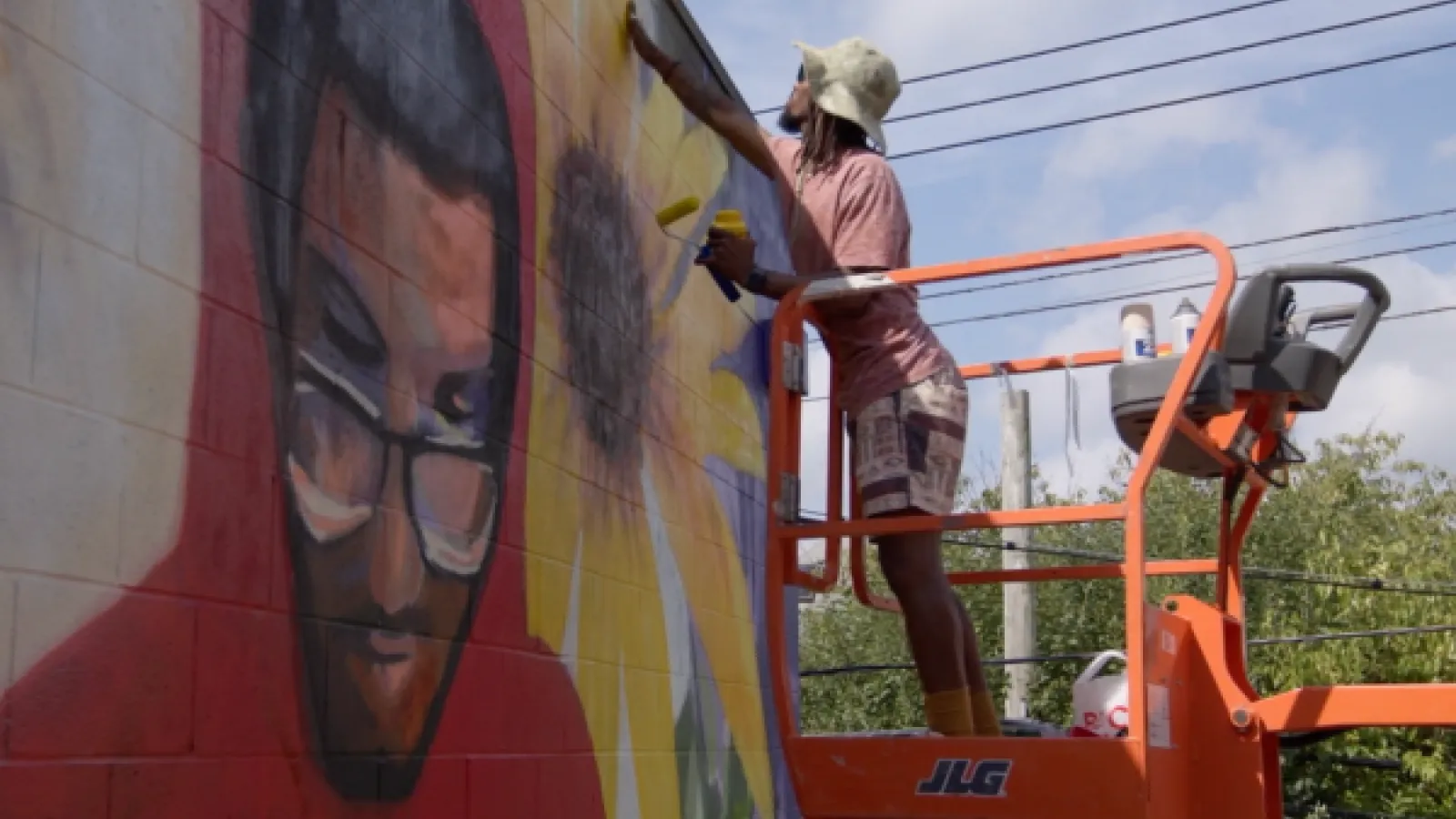 Arris' painting a mural of a student reading