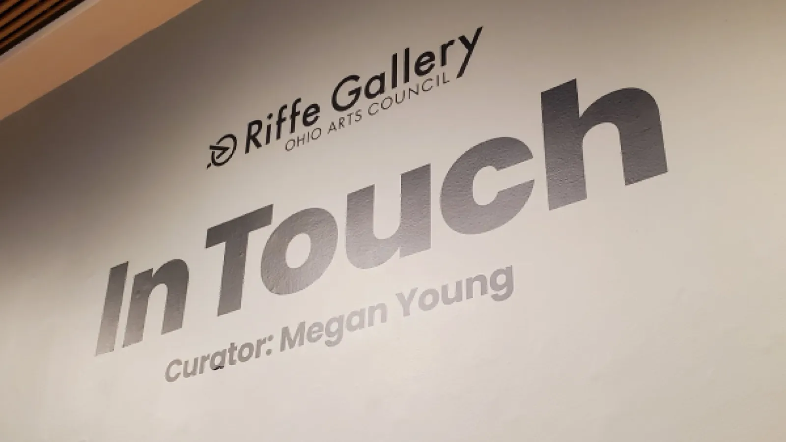 A sign on the wall states: "Riffe Gallery, In Touch, Curator: Megan Young"