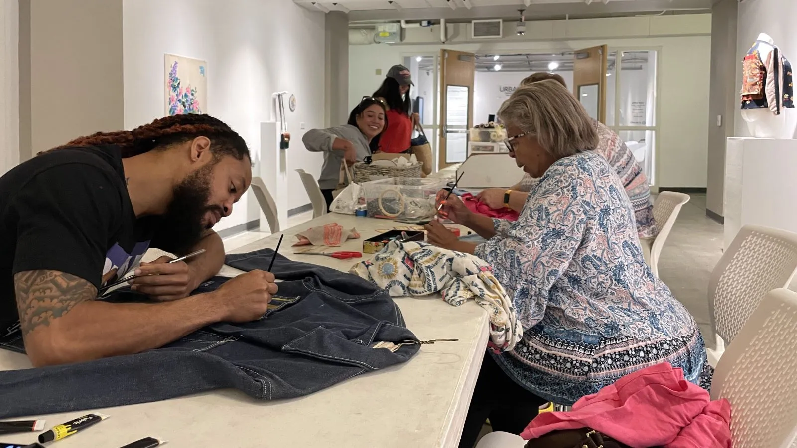Guests working at a table during Artist Commune: Fashion Upcycling.