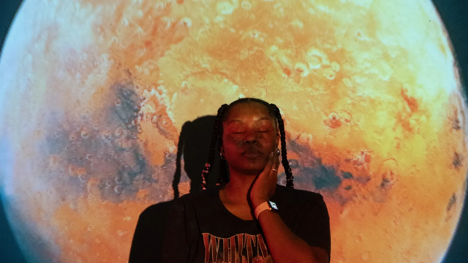 Ajanae silhouetted in front of a giant Mars