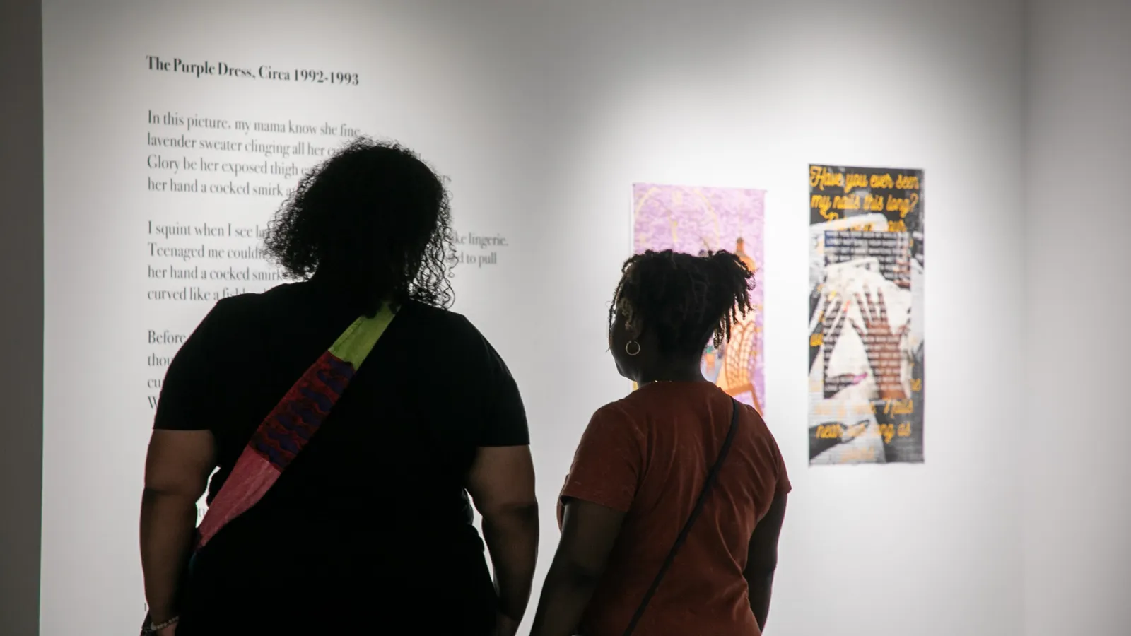 Two women looking at poetry and artwork.