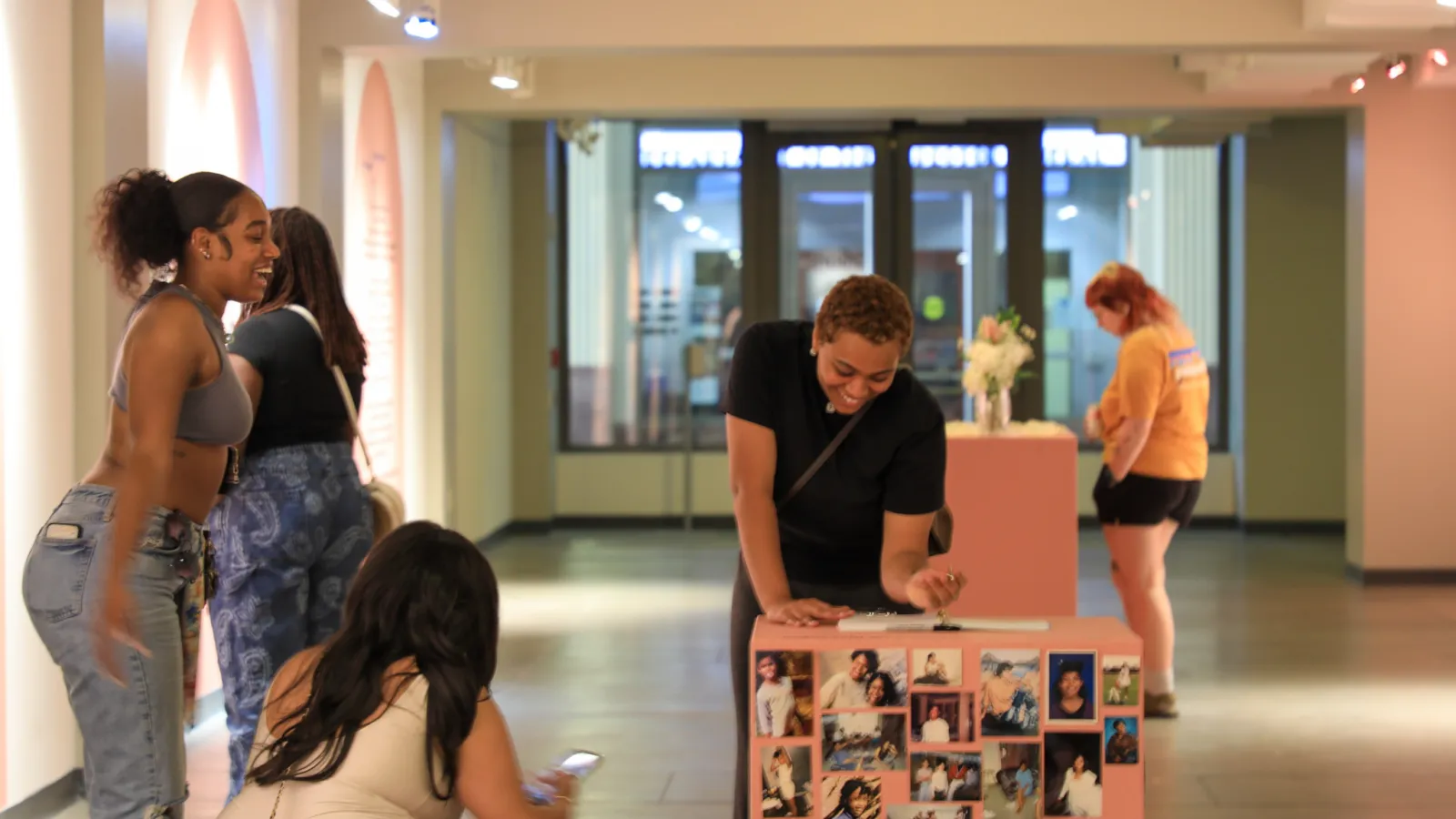 Several women writing and participating with the exhibition.
