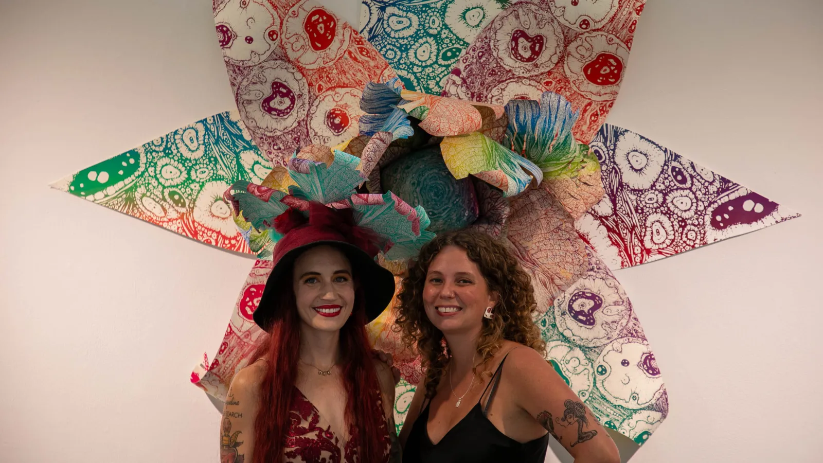 Stephanie and Alex posing in front of one of the decorative flowers