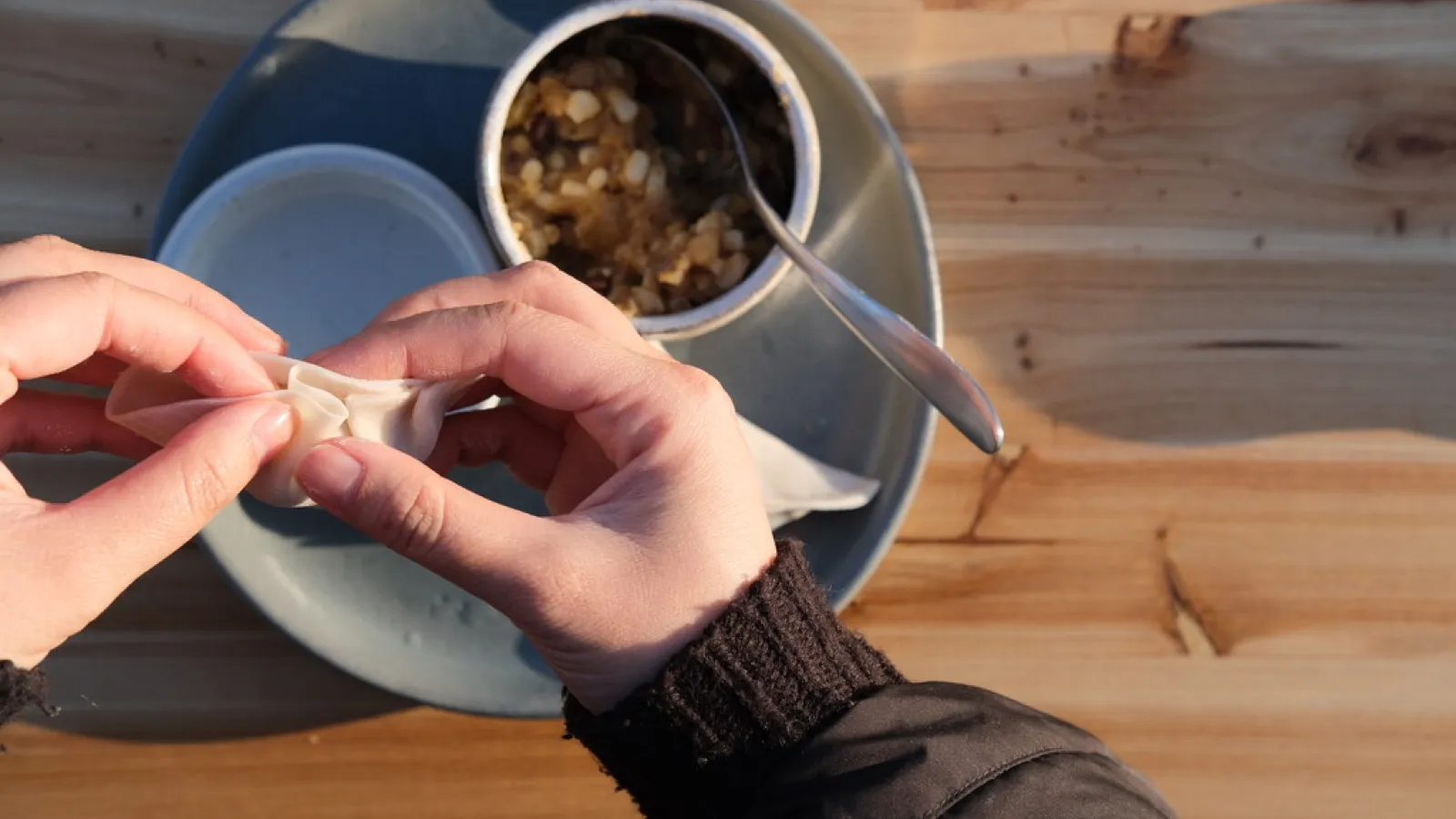 Hands making dumplings 