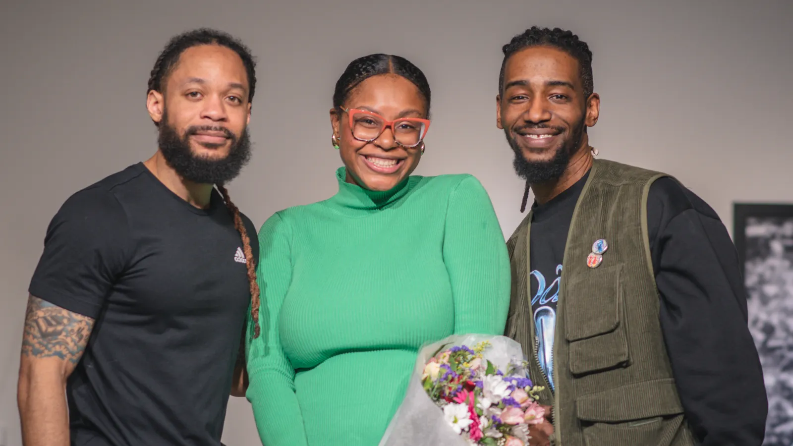 Ajanae in a green dress smiling with Dr. Terron Banner and Arris' Cohen