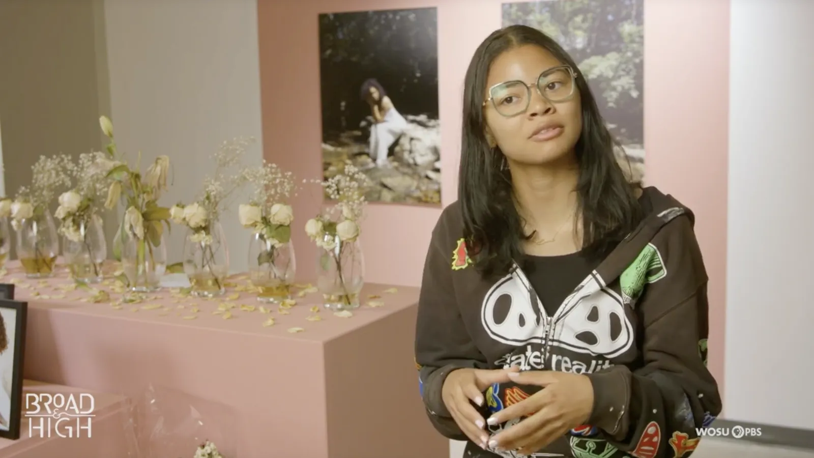 Iyana Hill sitting in front of her exhibition
